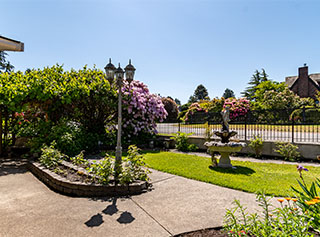 Courtyard with a stone water fountain, and statue of a young maiden in a long holding a basket.